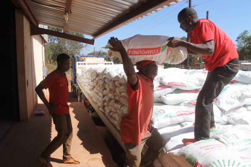 a group of men loading sacks on a truck